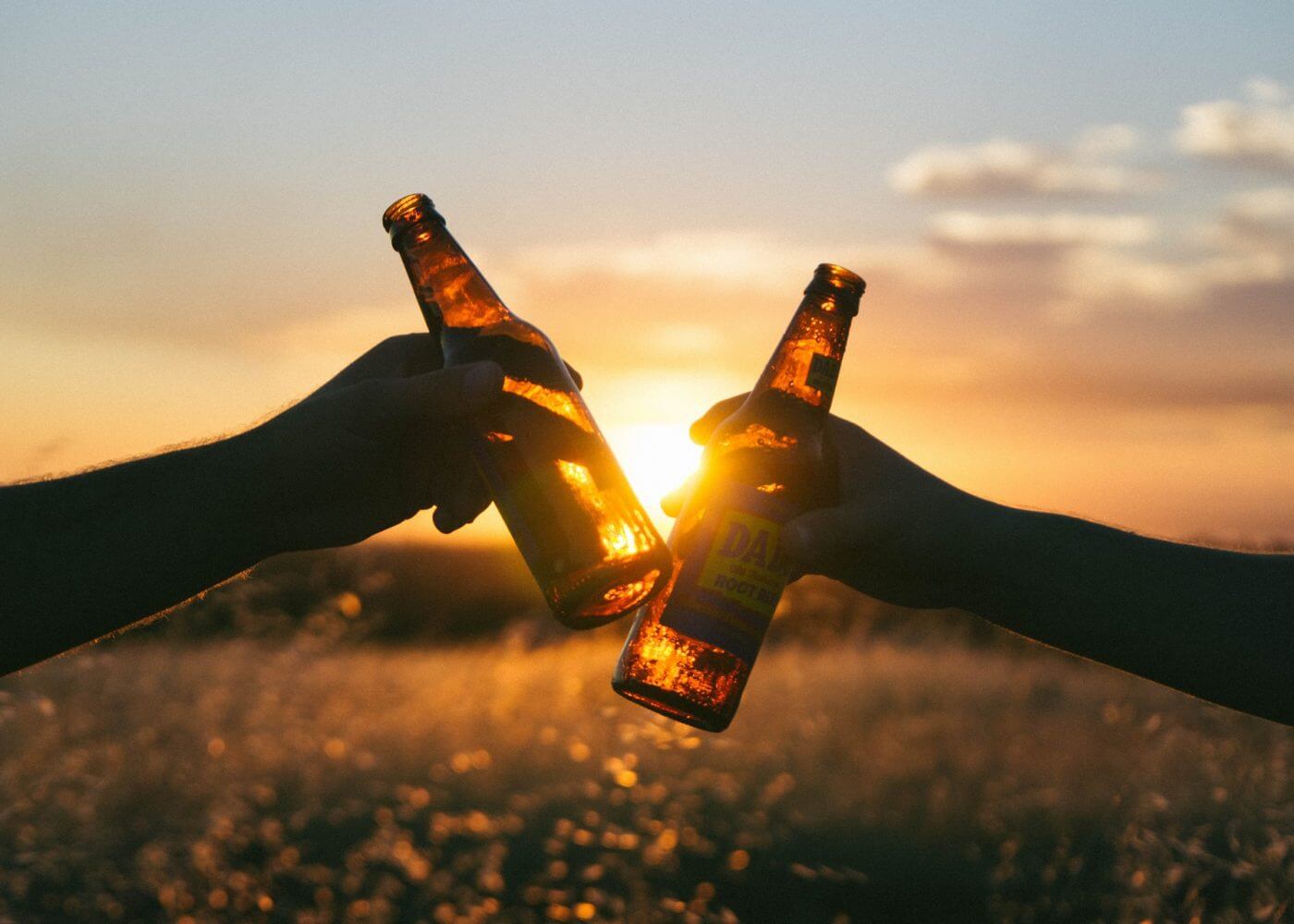 2 amis trinquant a la biere couche de soleil